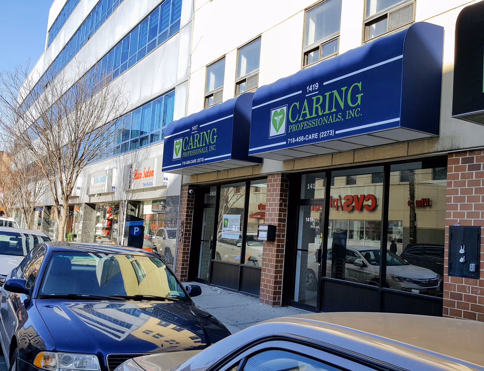 Exterior storefront with Caring Professionals signage and parked cars in front