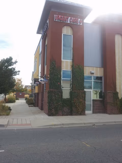 Exterior view of an urgent care clinic with ivy-covered brick columns.