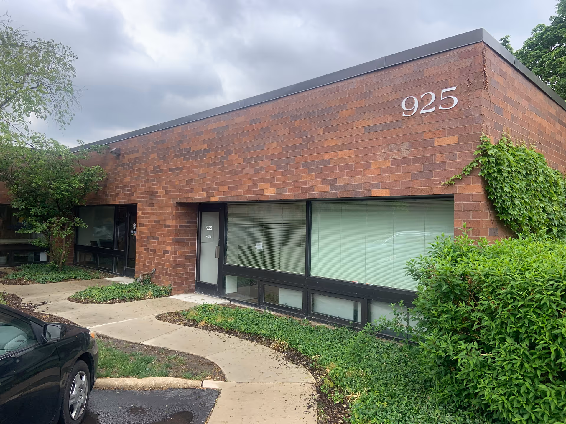 Brick building exterior with large windows and the number 925 on the wall.