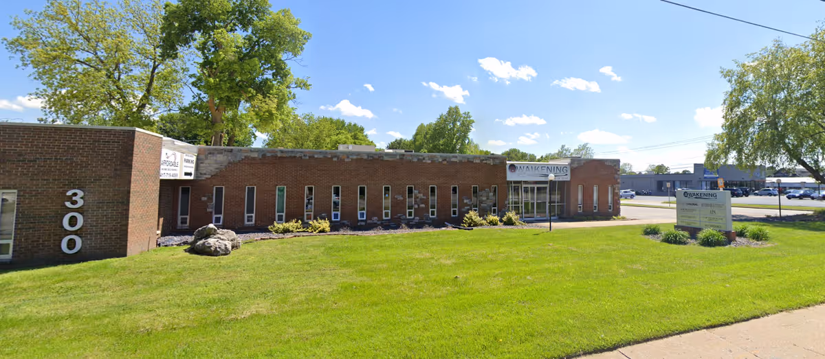 Brick single-story facility with a manicured lawn and front signage.