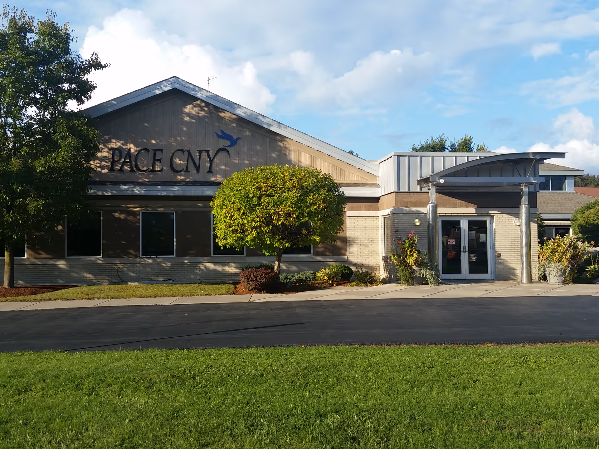 Exterior view of Sally Coyne PACE Center with entrance and landscaped front