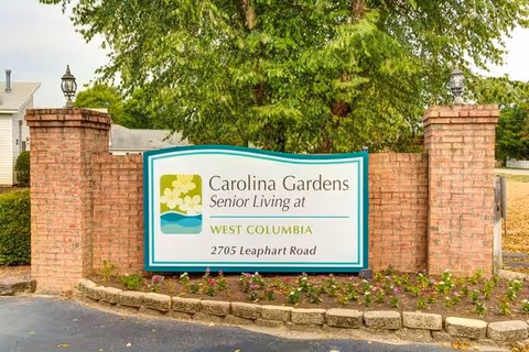 Outdoor entrance sign for Carolina Gardens Senior Living at West Columbia, flanked by brick pillars