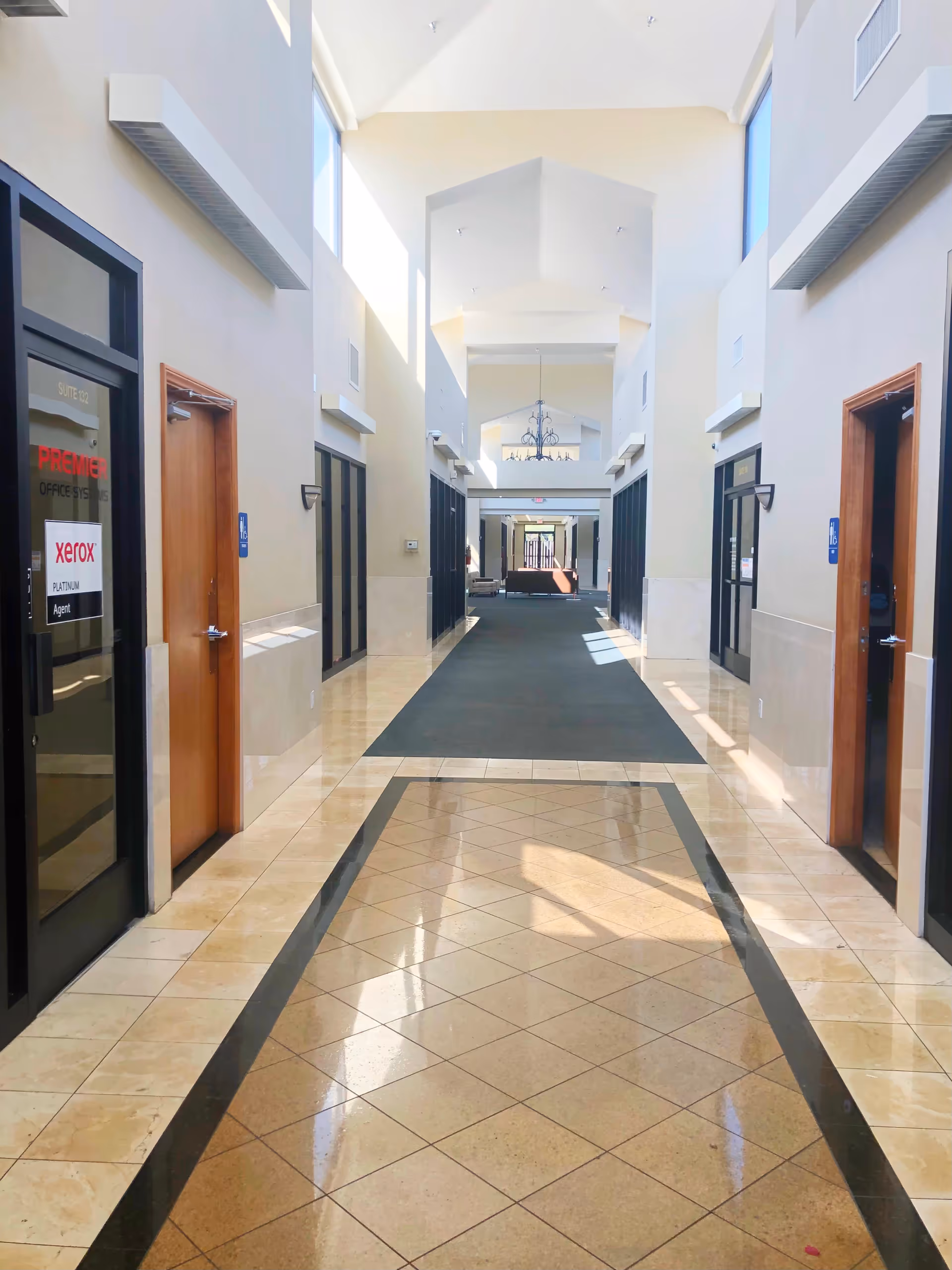 Bright interior hallway of a hospice care facility with doors along both sides