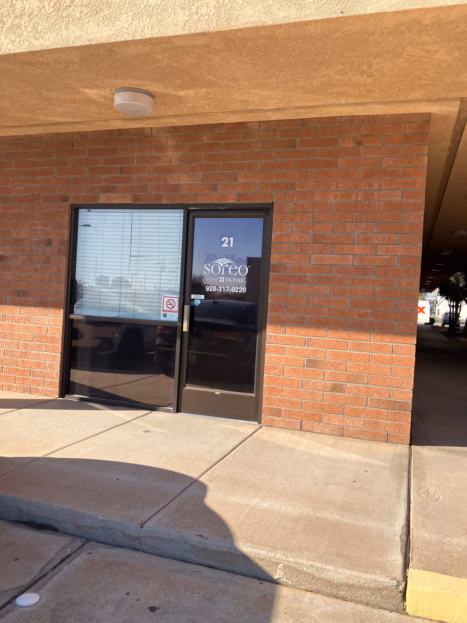 Brick exterior with glass door labeled Soreo Mosaic and number 21.