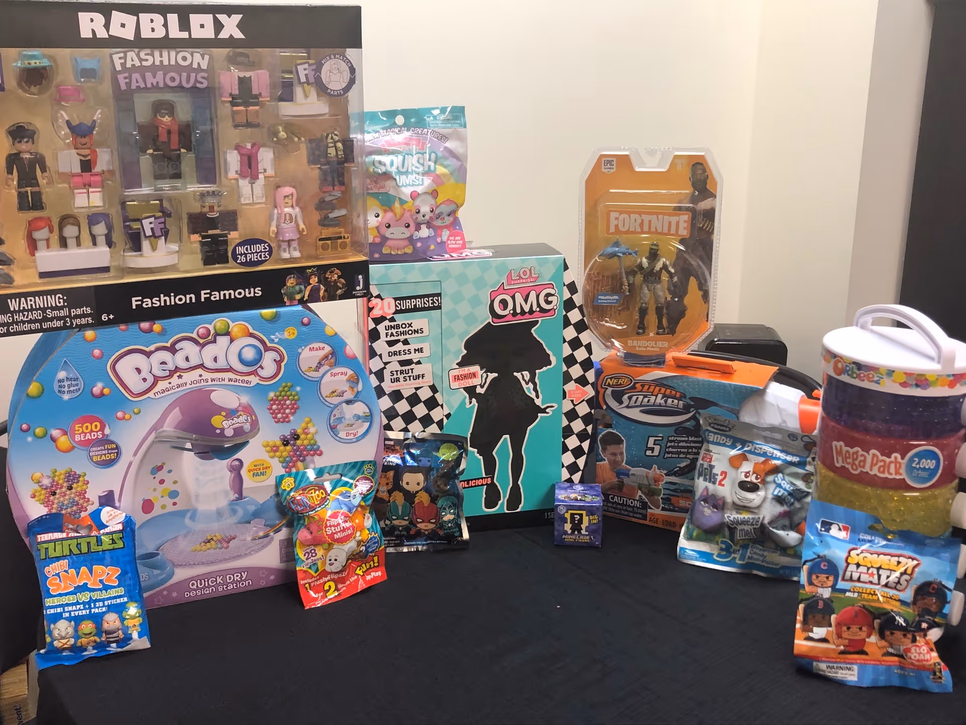 Colorful toy boxes and packages arranged on a dark floor against a wall.