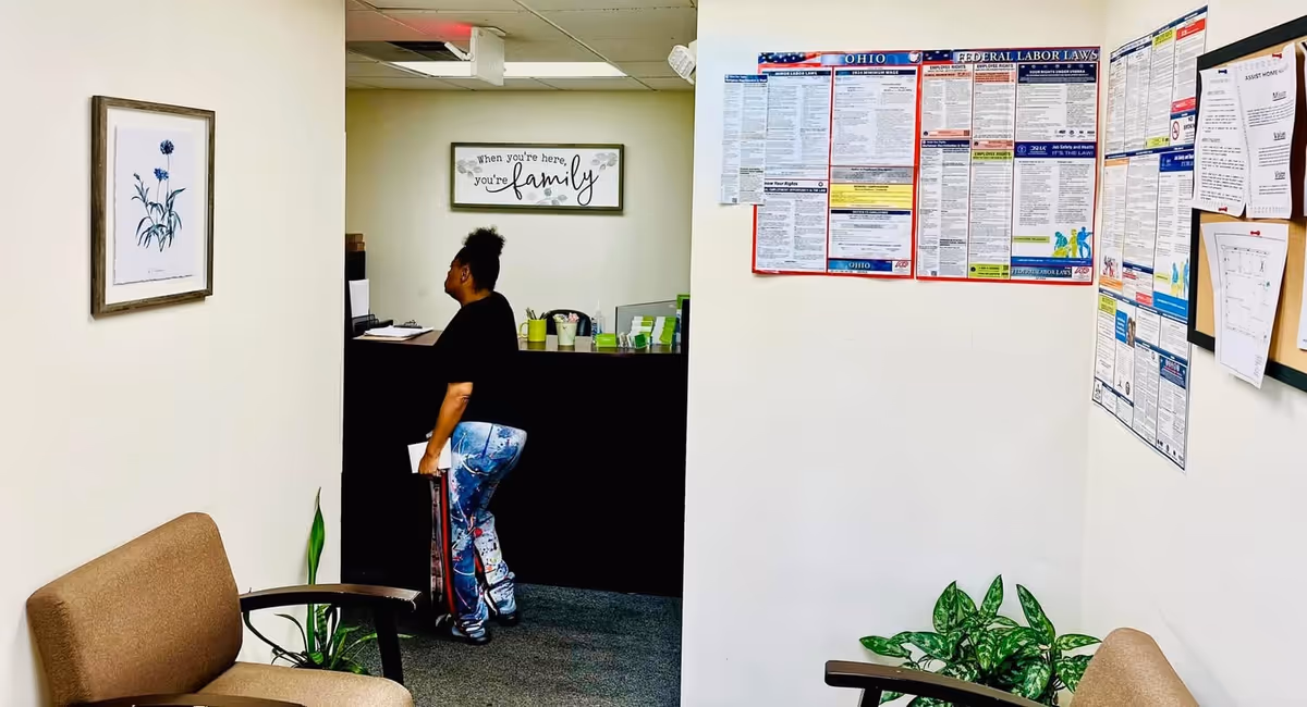 Reception desk inside a senior care facility lobby with a staff member.