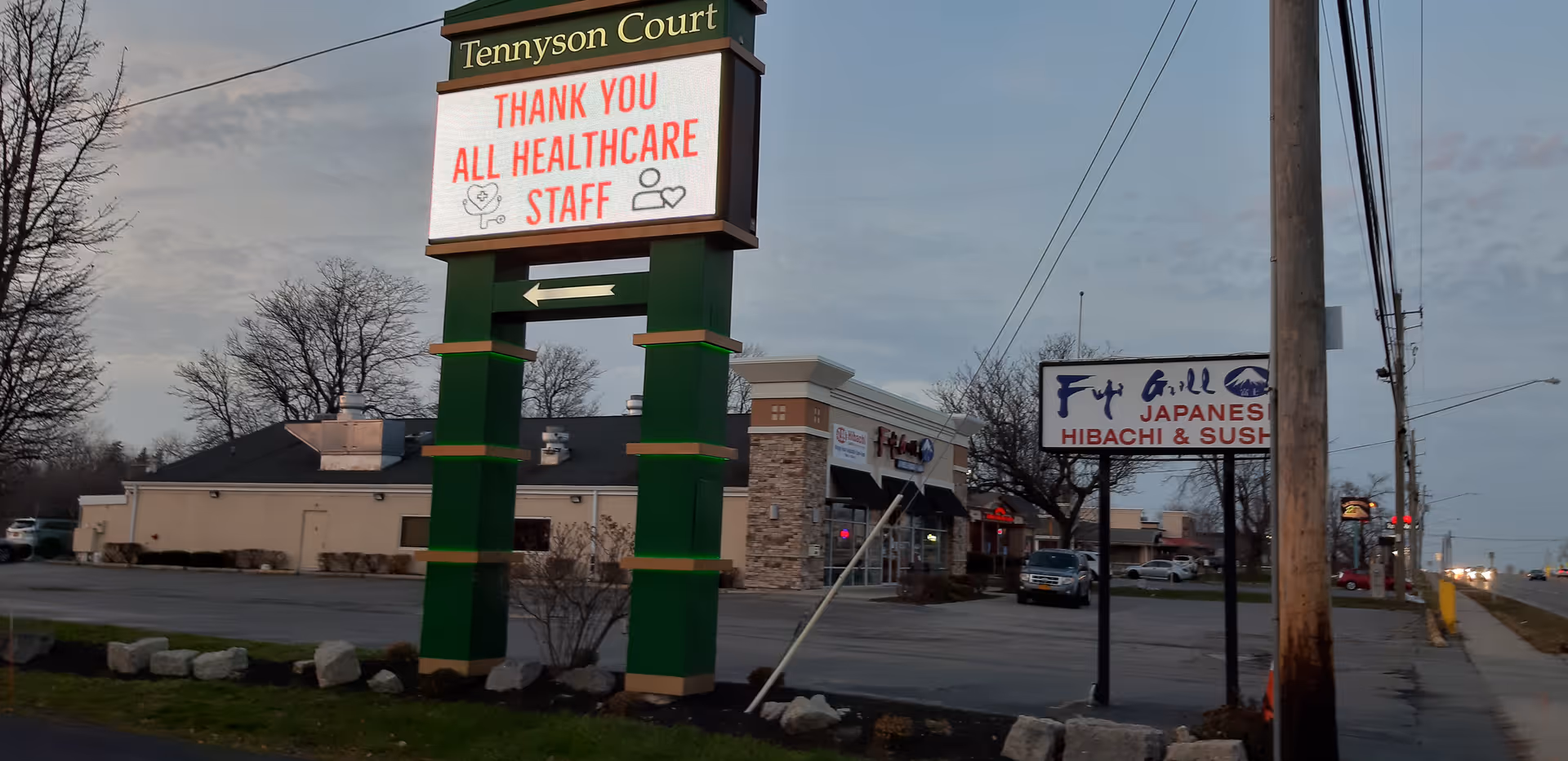 Outdoor view of Tennyson Court sign with a digital message thanking healthcare staff near a street.