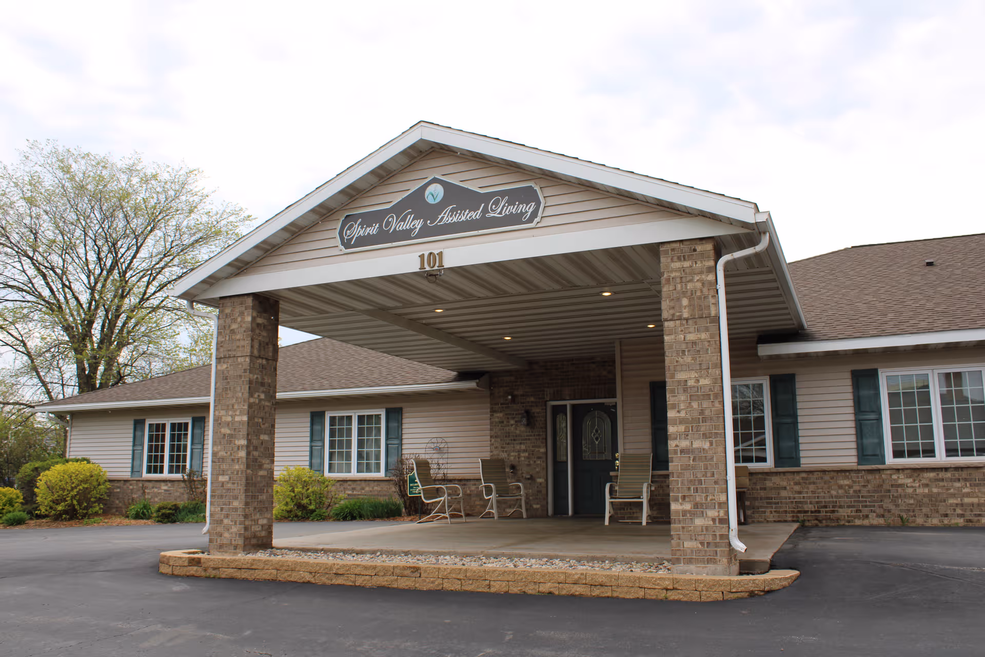 Exterior view of a single-story assisted living facility with brick columns and a covered entrance.