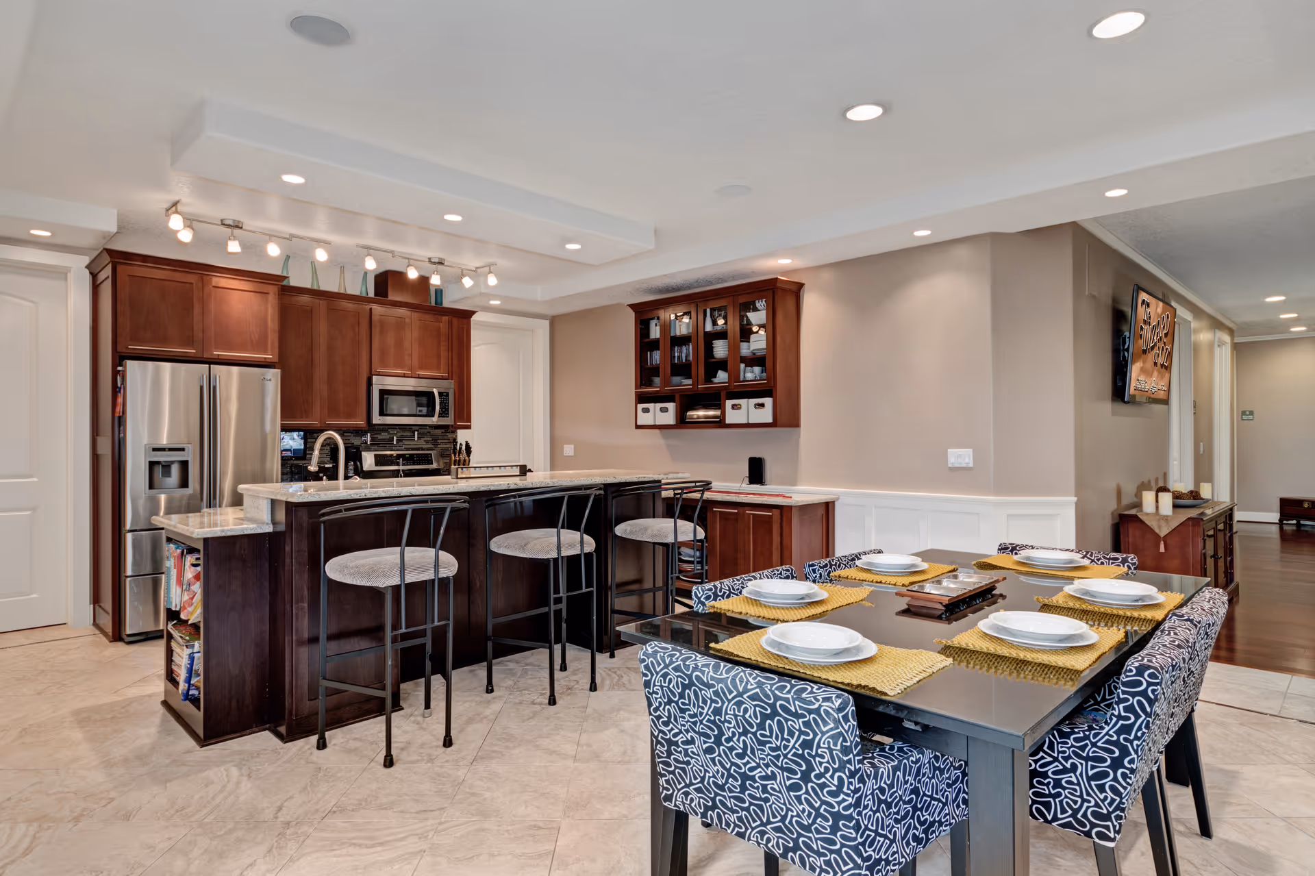 Open-concept kitchen with dark wood cabinets, stainless appliances, and a six-seat dining table.