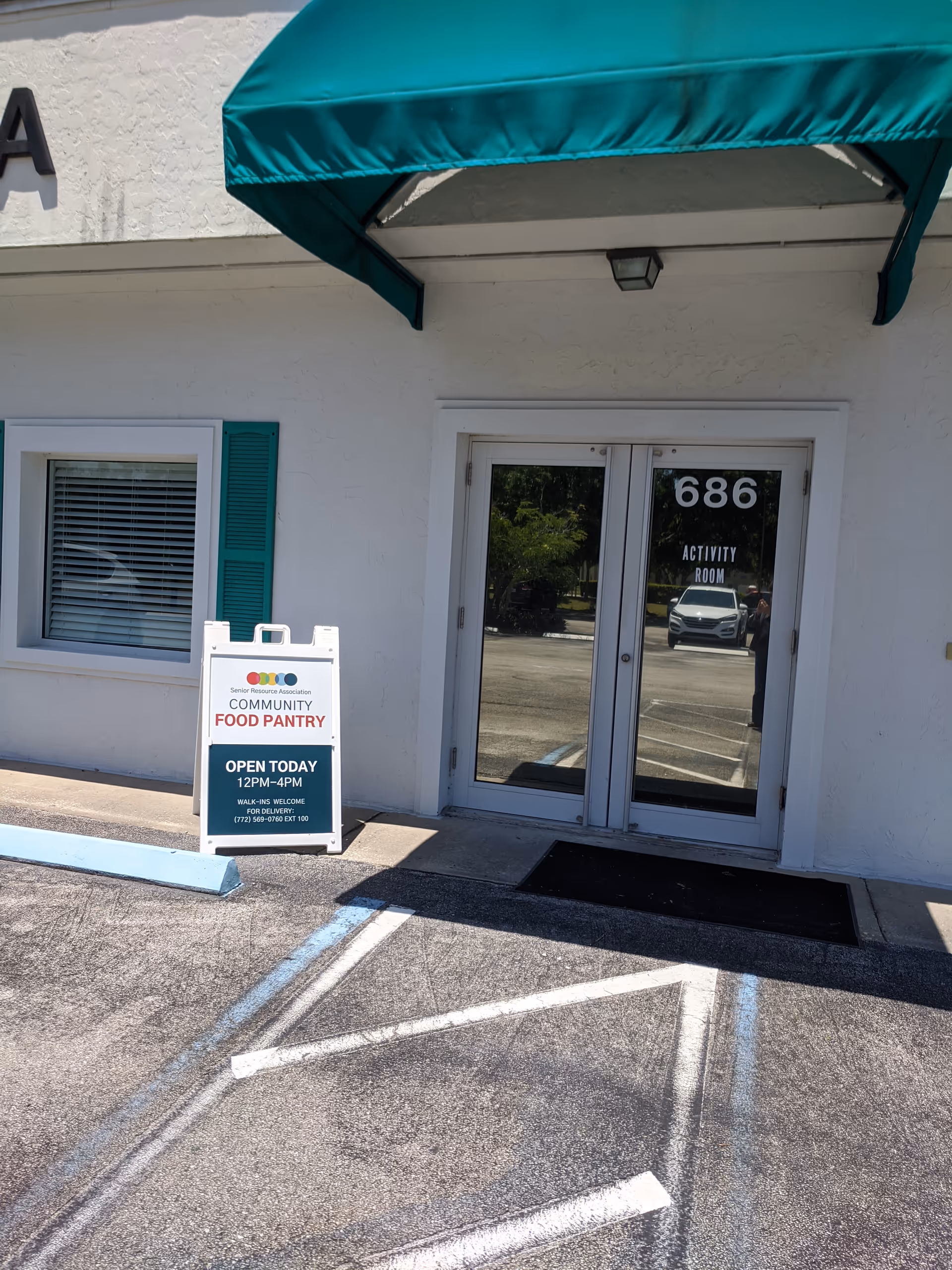 Exterior view of Senior Resource Association entrance with a community food pantry sign
