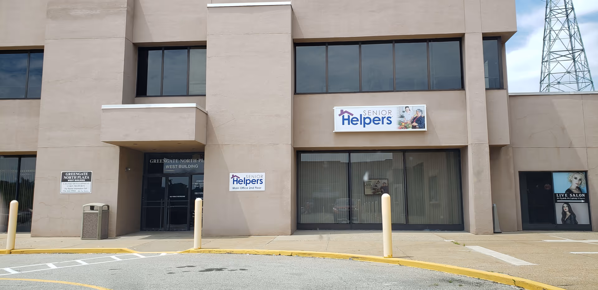 Beige corporate building exterior featuring Senior Helpers signage above the glass front entrance.