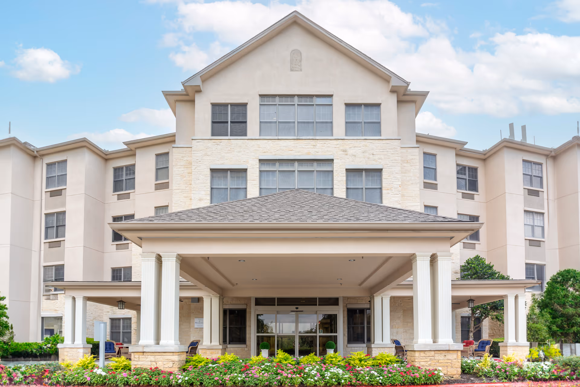 Front view of Brookdale Northwest Hills, a multi-story building with a covered entrance and landscaped garden.