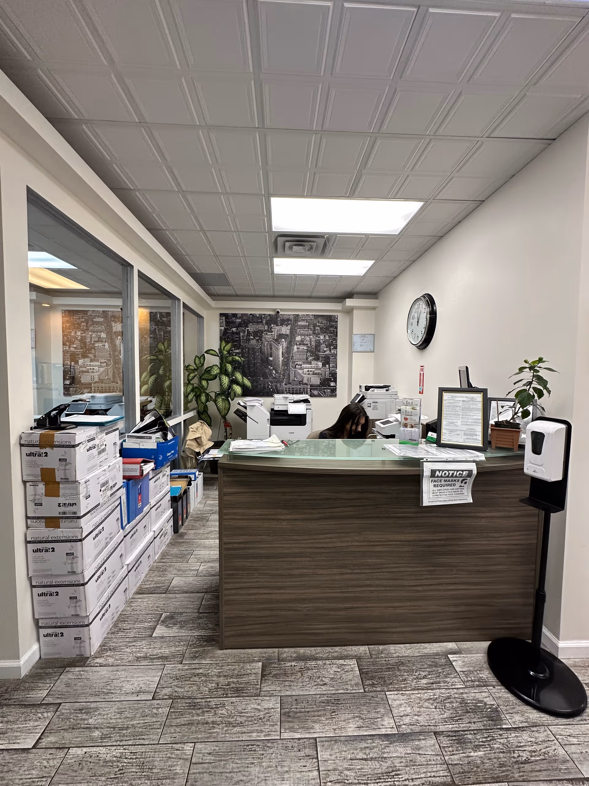 Reception desk inside City Choice Home Care Services with boxes, printers, and a staff member.