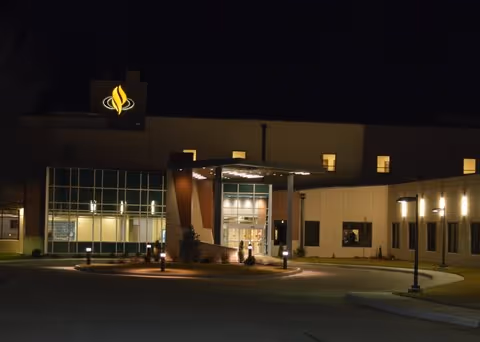 Night exterior of Pratt Regional Medical Center entrance with illuminated sign and glass facade.