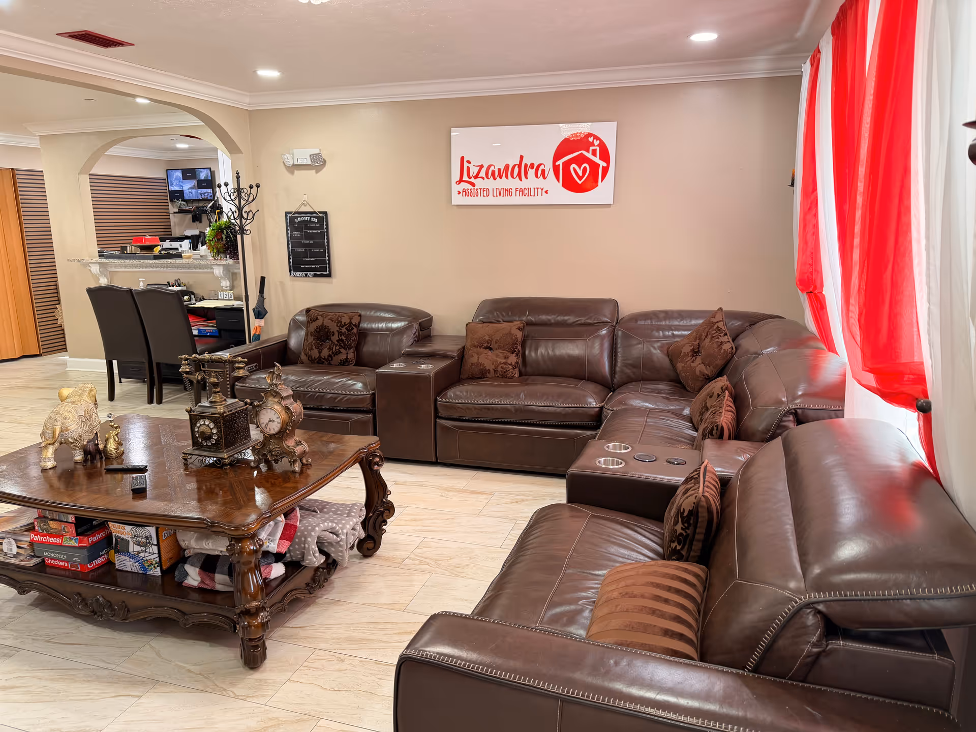 Cozy living room inside Lizandra Assisted Living Facility with leather sectional and coffee table.