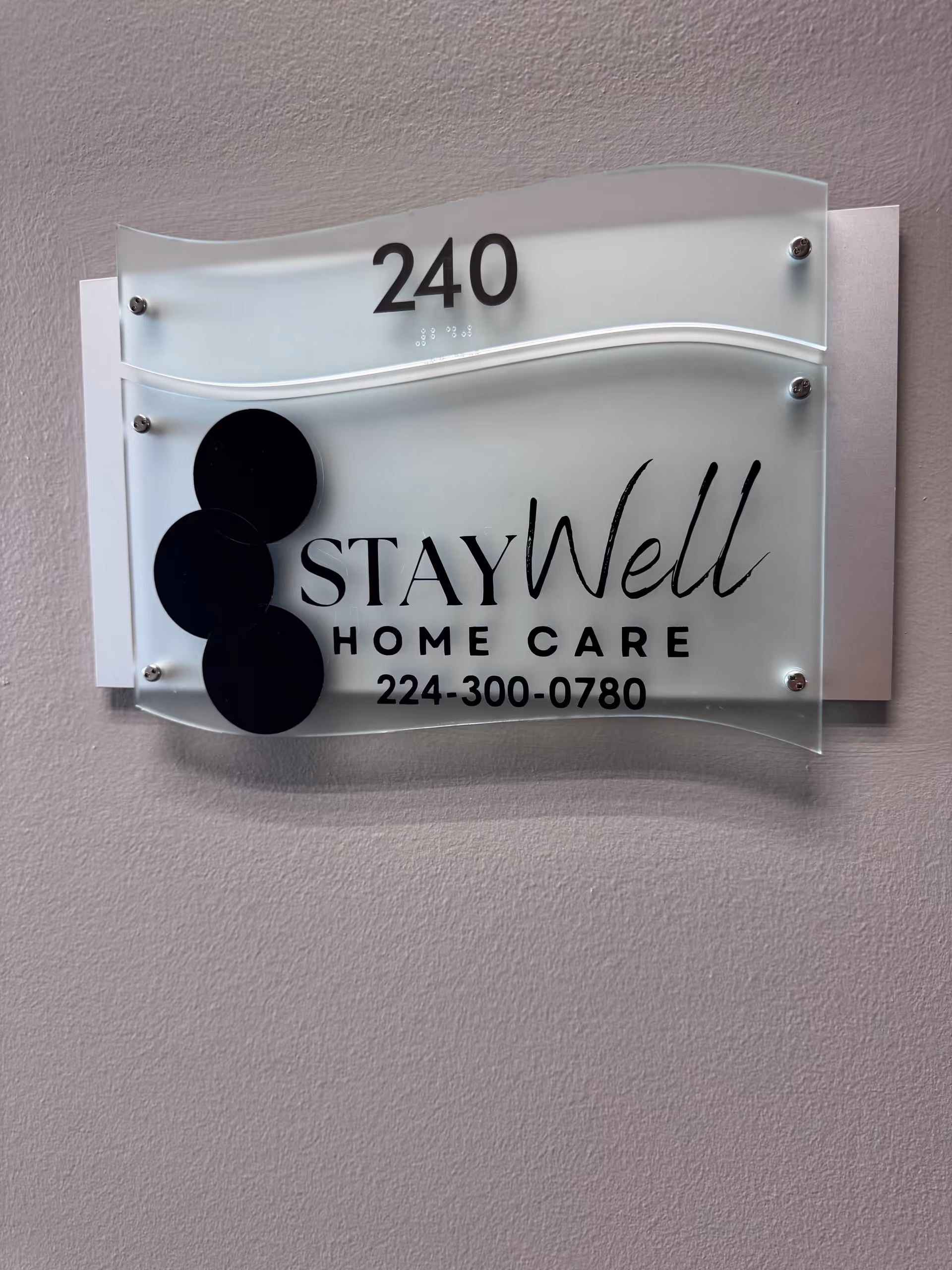 Wall sign showing StayWell Home Care with room 240 and phone number