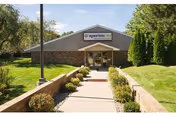 Exterior view of Aperion Care Arbors Michigan City entrance with walkway and landscaping.