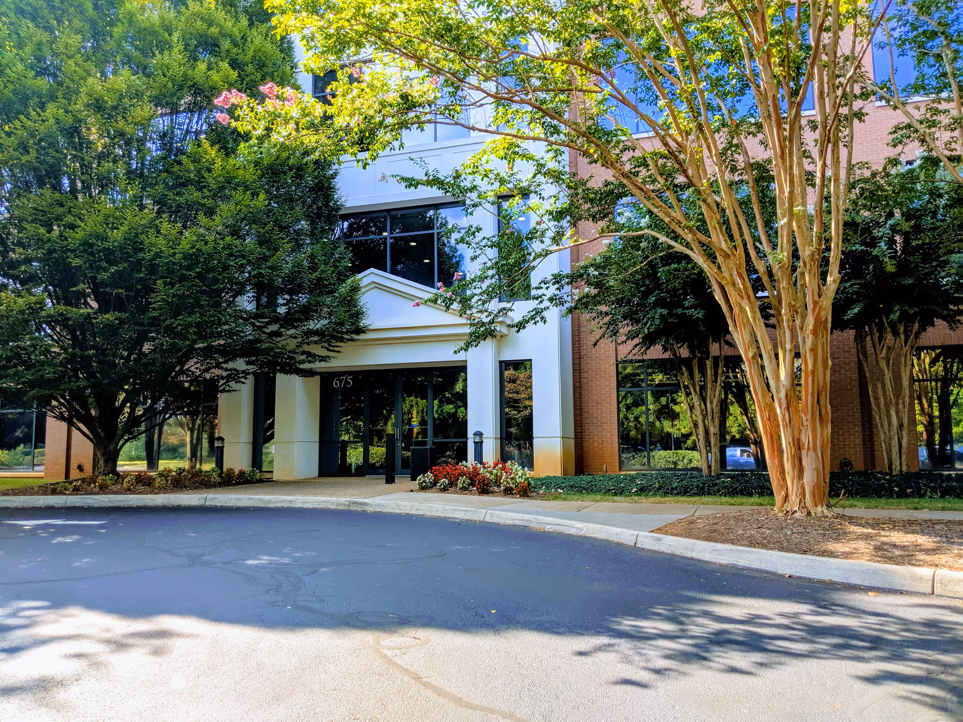 Front entrance of Hospice of the Piedmont surrounded by trees and landscaping