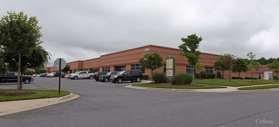 Exterior view of a brick senior care facility with a parking lot and landscaping.