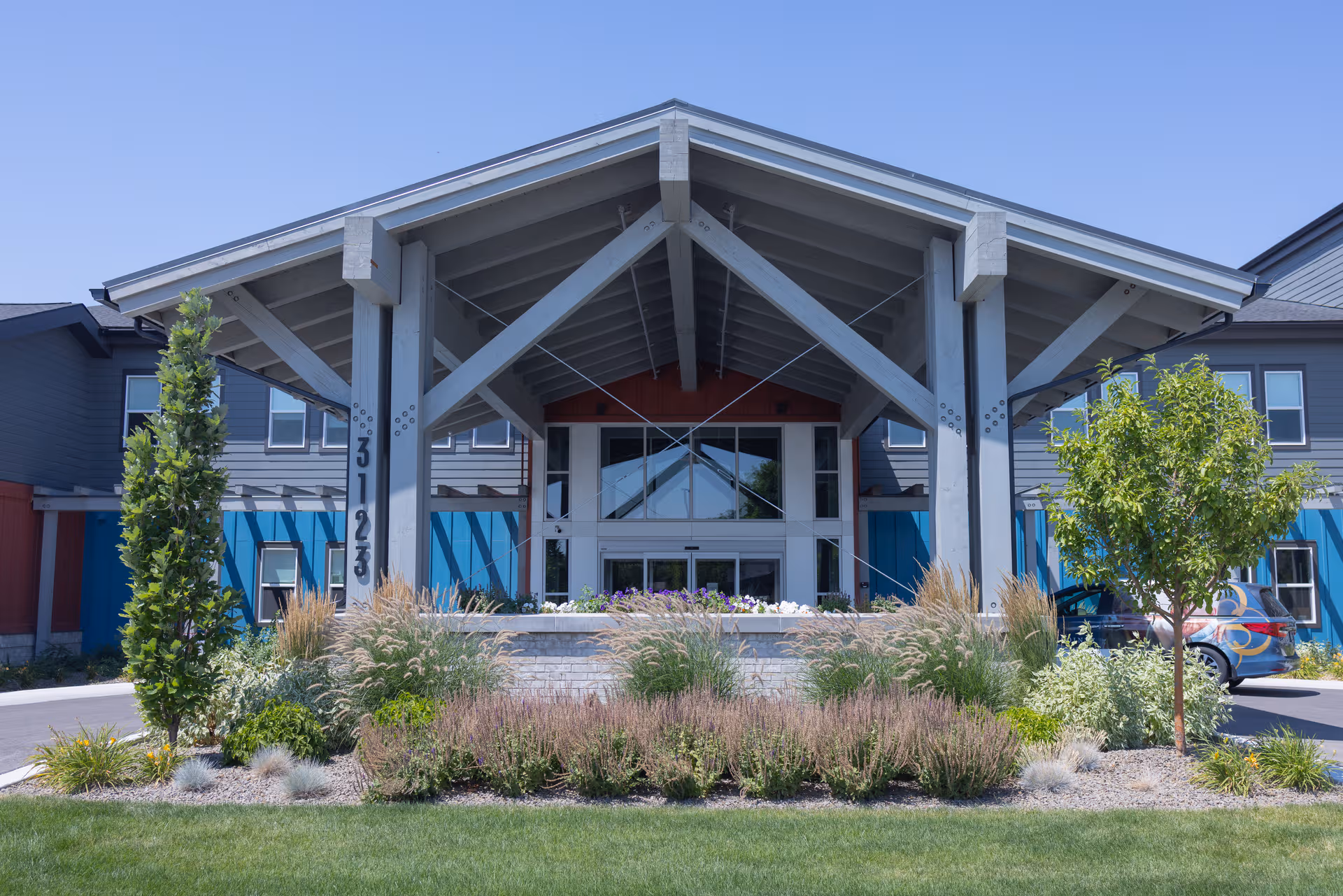 Front entrance of The Pointe at Meridian with a large wooden canopy and landscaping