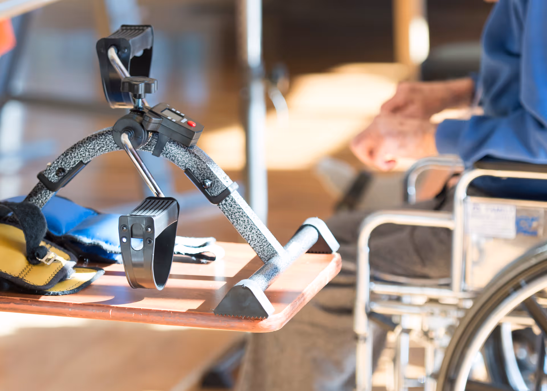 Assistive mobility device on a wooden table beside a wheelchair.