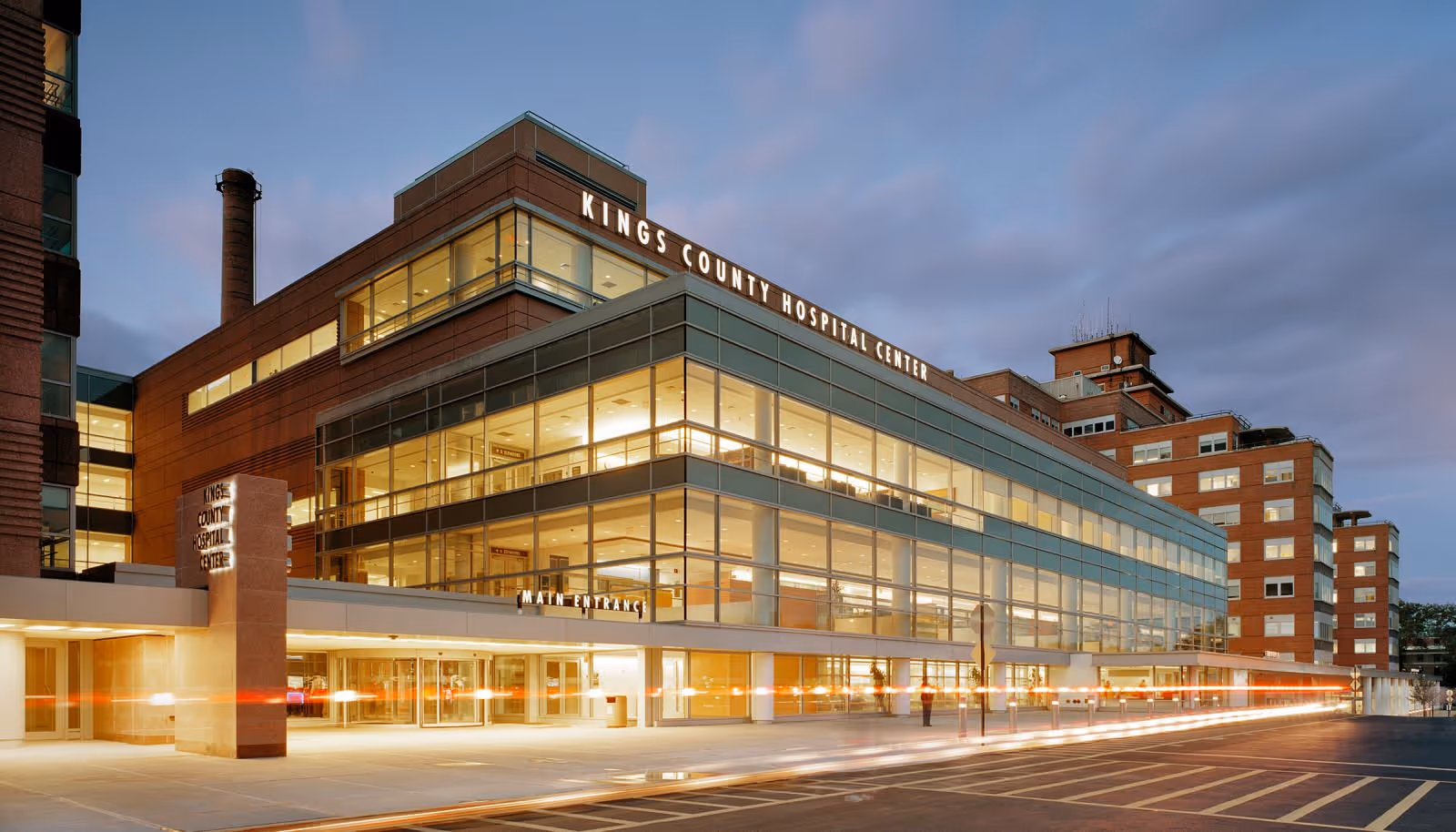 Exterior view of a modern hospital building with glass walls and a main entrance.