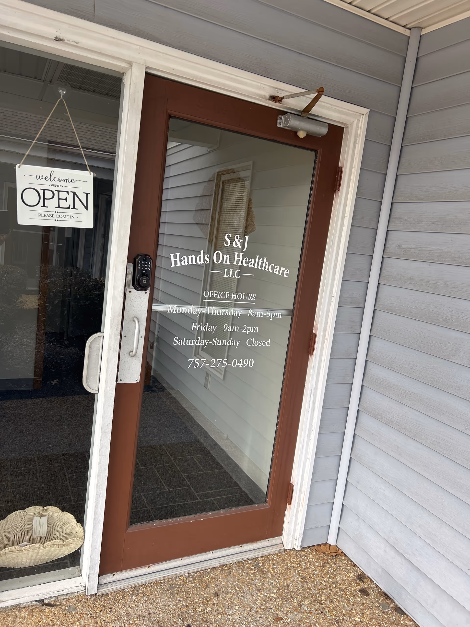 Glass entry door for S&J Hands On Healthcare LLC with hours posted.