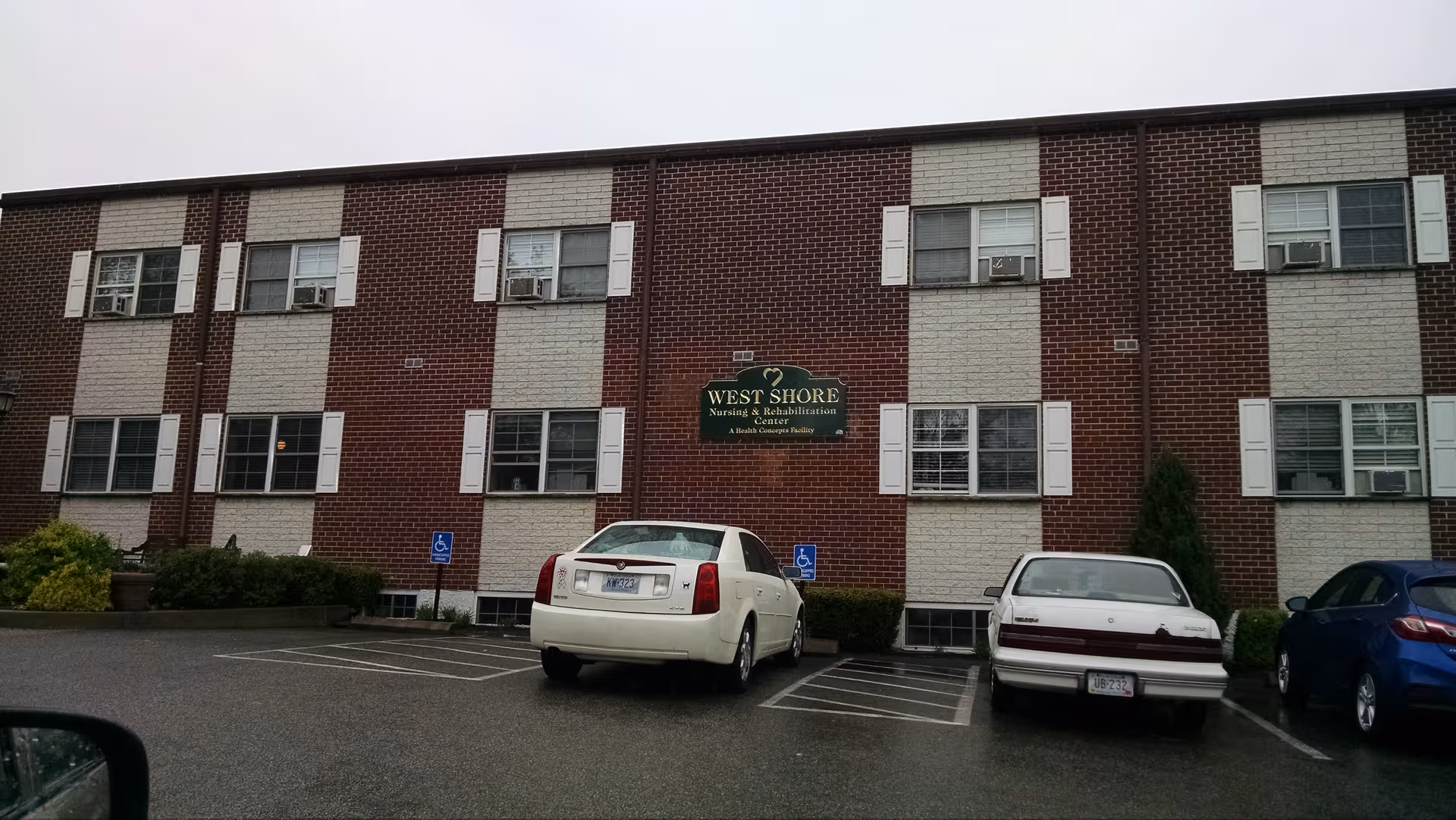 Brick senior living building with cars parked in front and a West Shore sign.