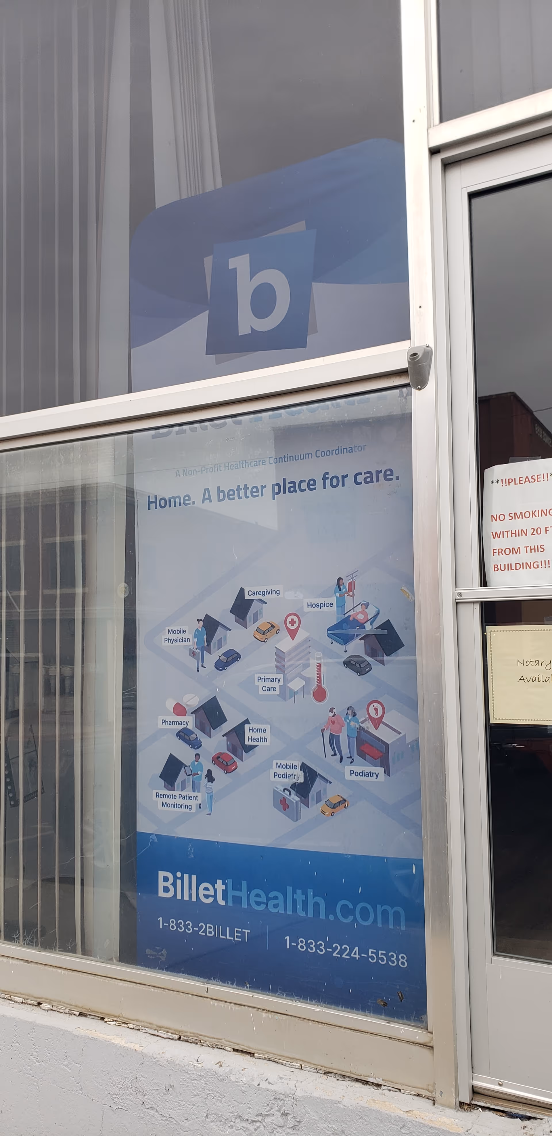 Glass storefront with BilletHealth poster, blue logo, and an entrance door.