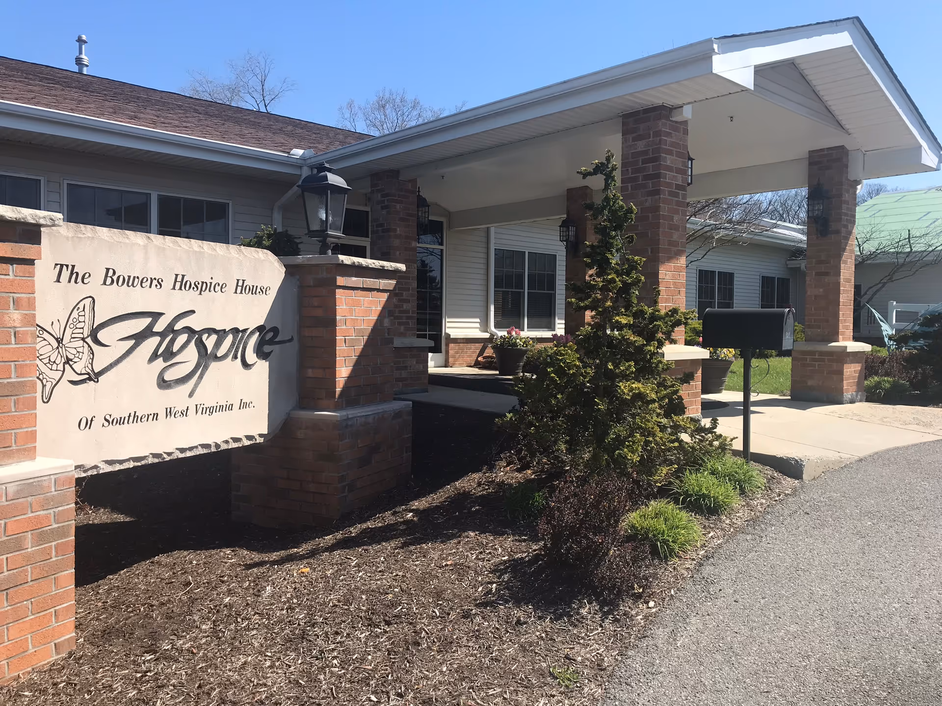 Brick-front hospice building with a prominent sign near the entrance.