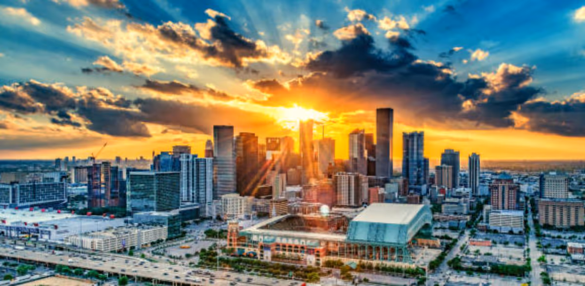 Vibrant city skyline at sunset with tall buildings and dramatic clouds.