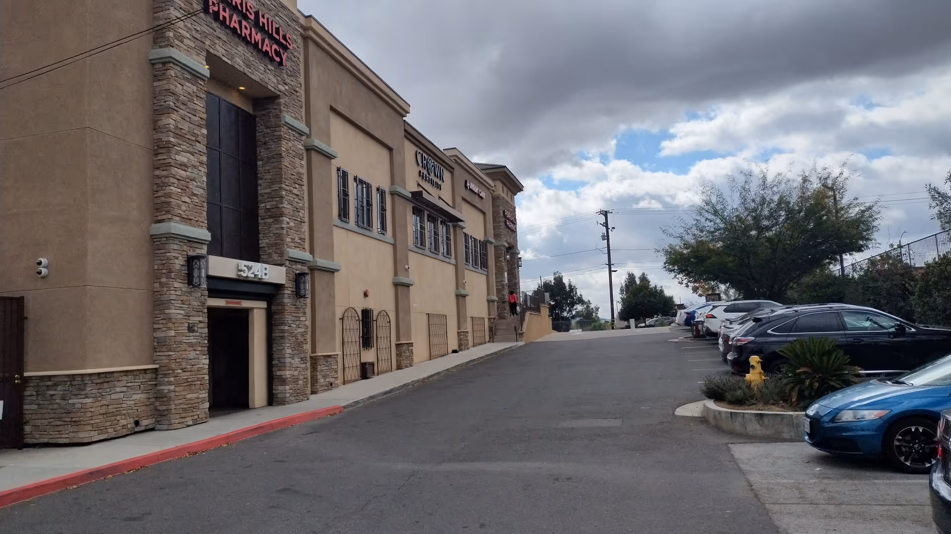 Exterior view of Perris Clinic Urgent Care building with parked cars along the curb.