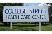 A white outdoor sign reads College Street Health Care Center on a grassy lawn.