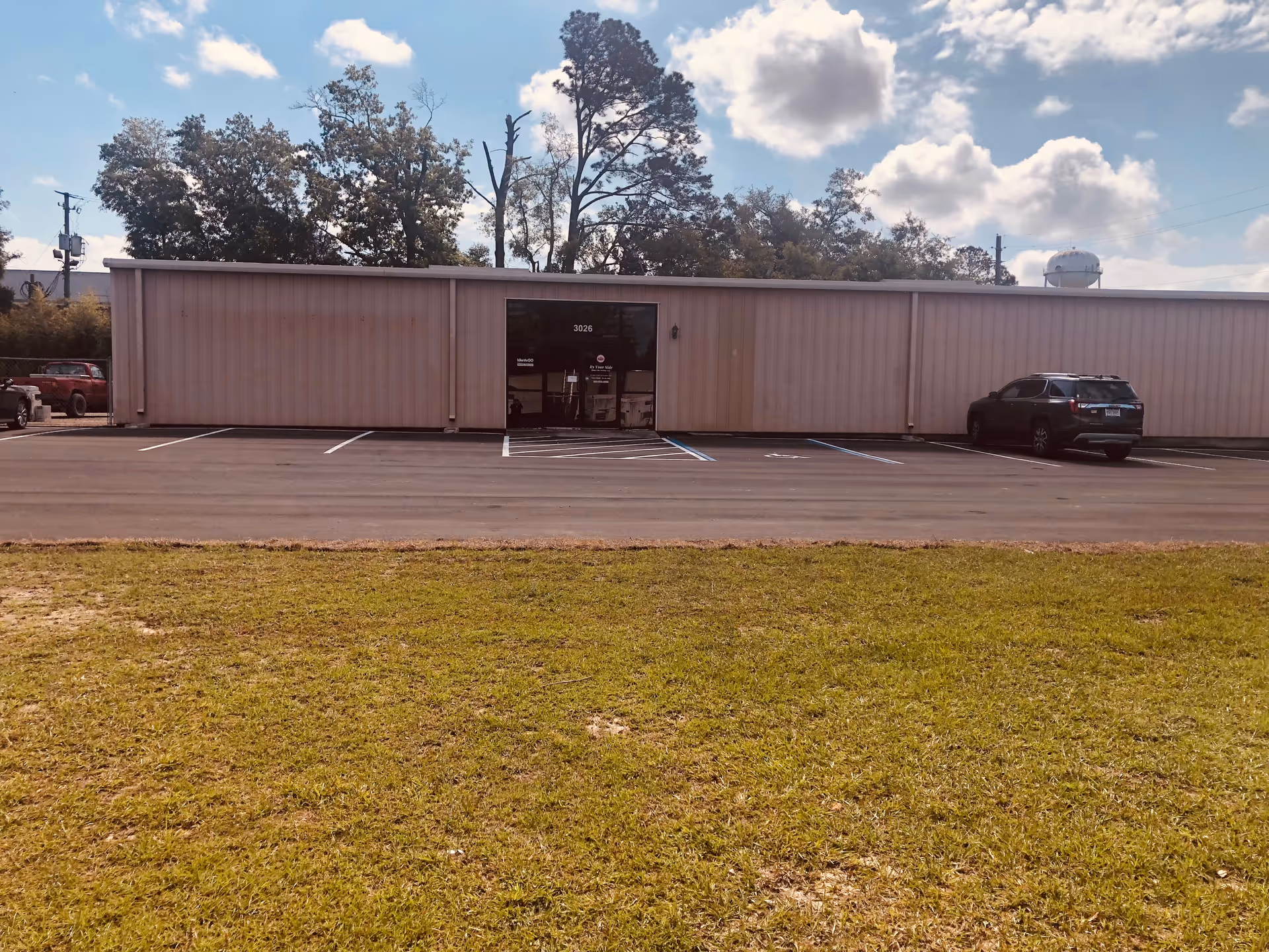 Exterior view of a single-story facility with parking and central entrance.