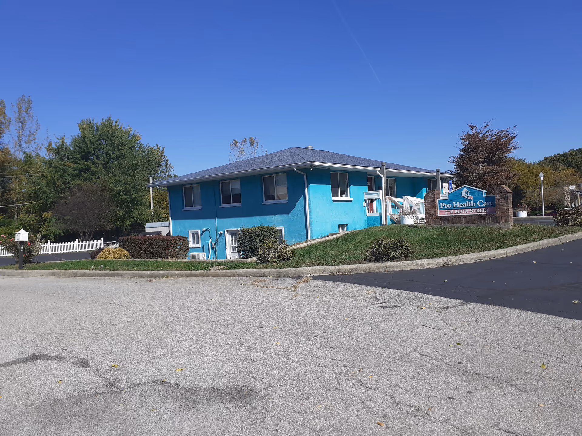 Blue single-story facility building with a Pro Health Care Services sign in a parking lot
