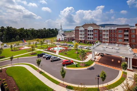 Redwood Manor Assisted Living exterior with circular drive, red-brick building, and manicured lawn.