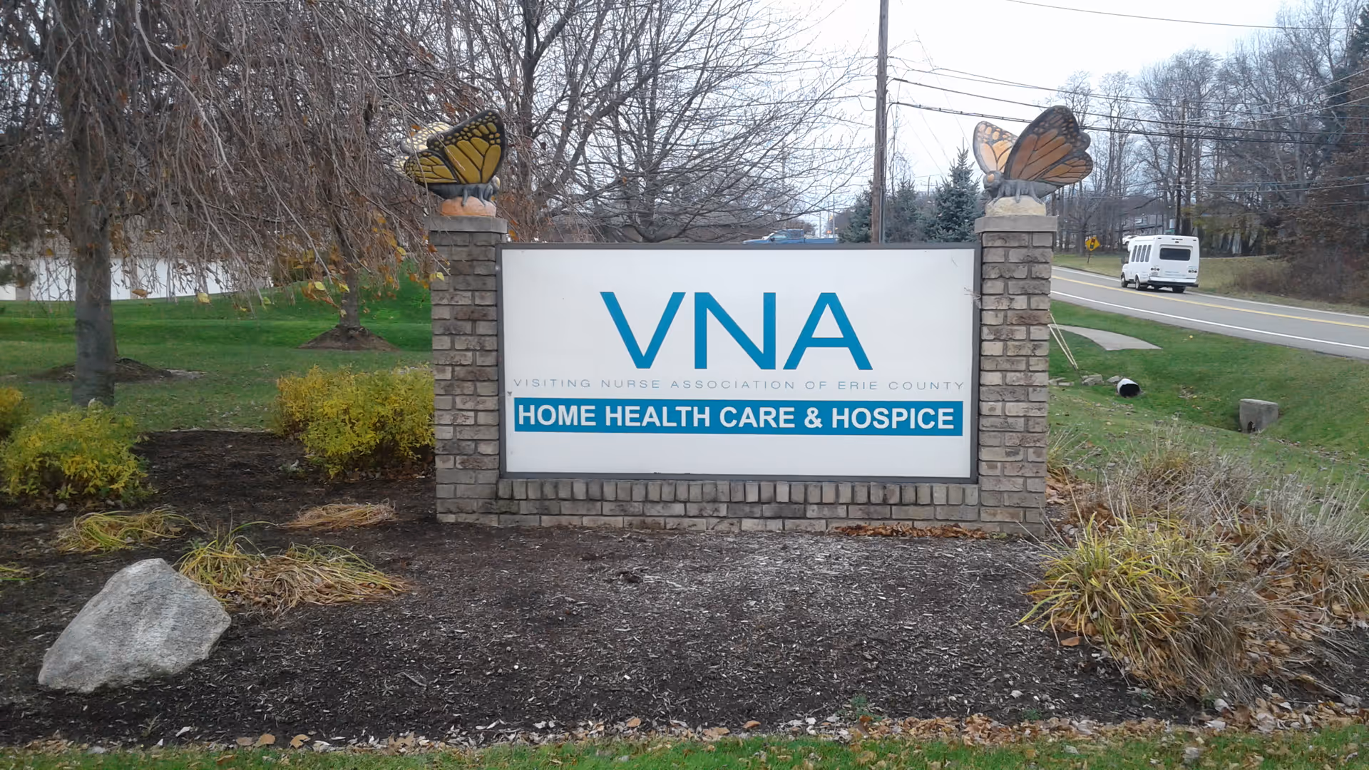 Outdoor VNA Erie County sign on brick pillars with butterfly toppers.