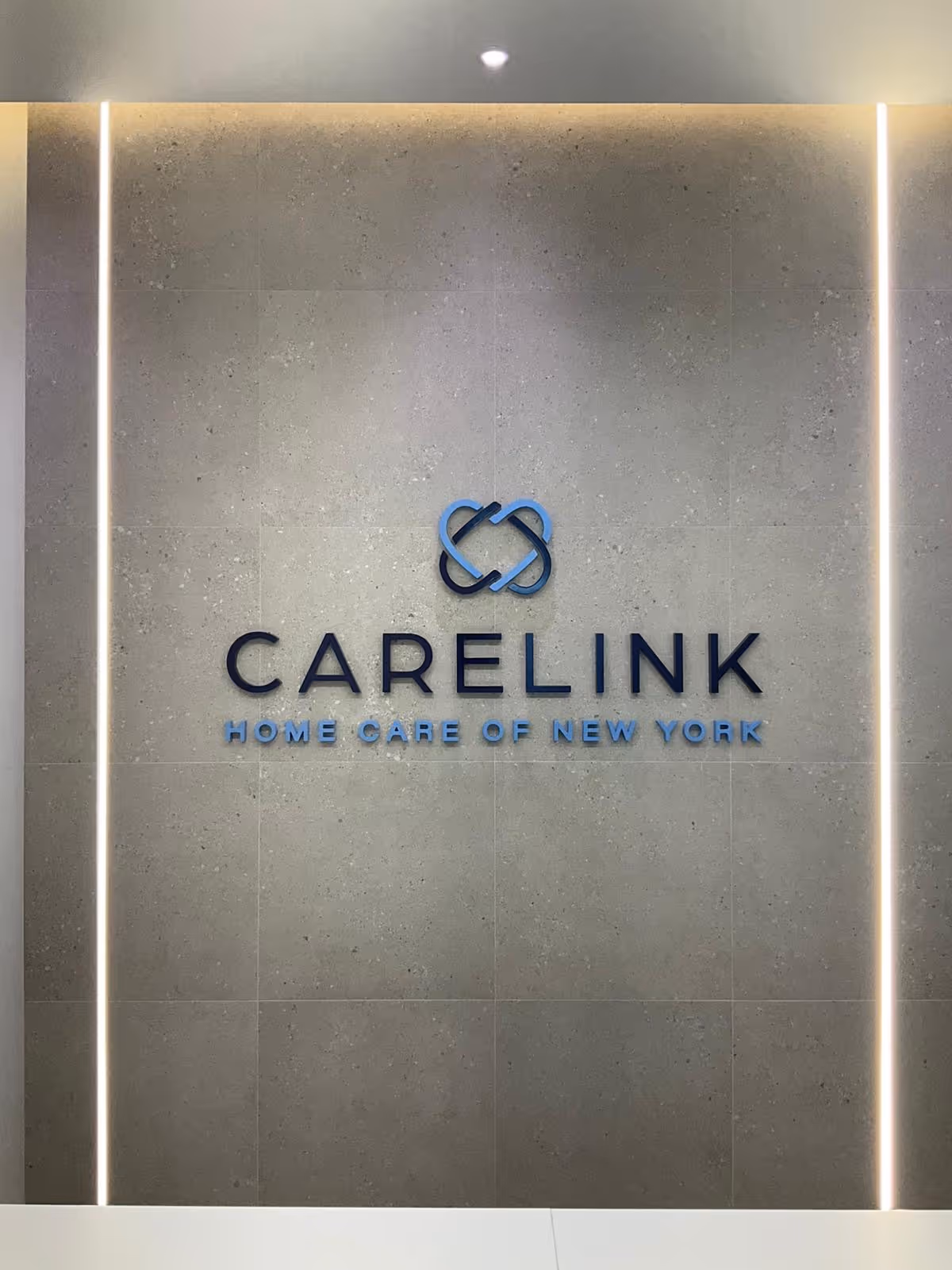 Indoor wall features Carelink logo and blue lettering for Home Care of New York.