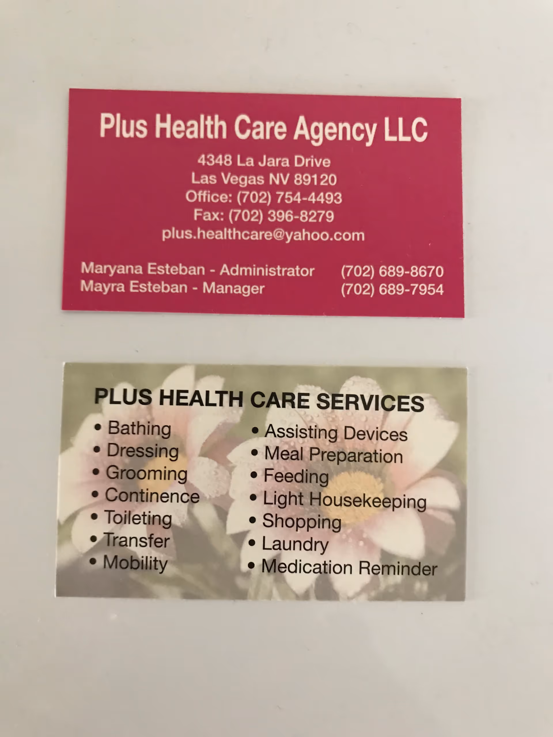 Two business cards for Plus Health Care Agency LLC are affixed to a wall.