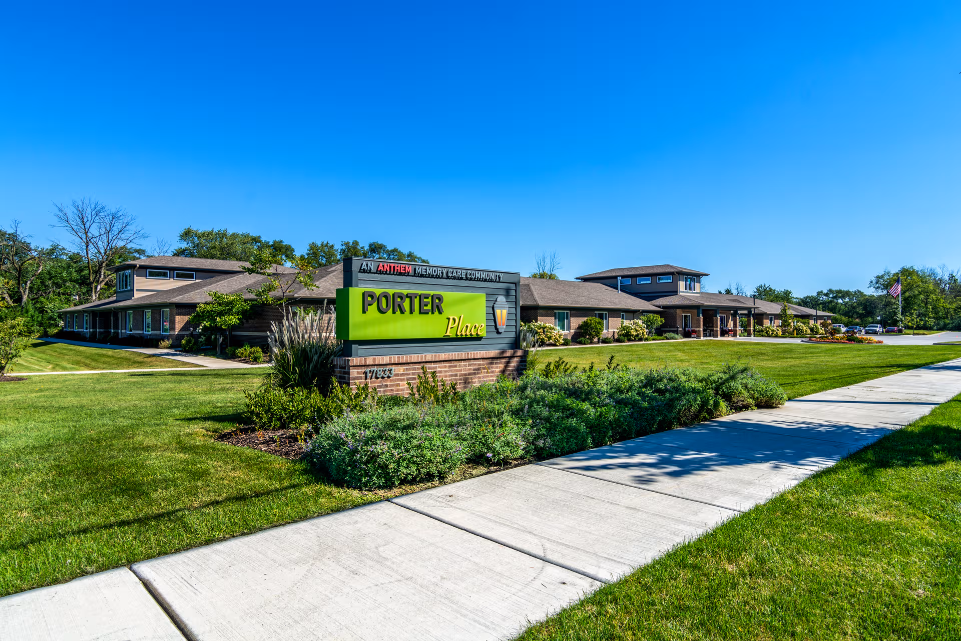 Wide exterior view of Porter Place senior living with a bright green entrance sign.