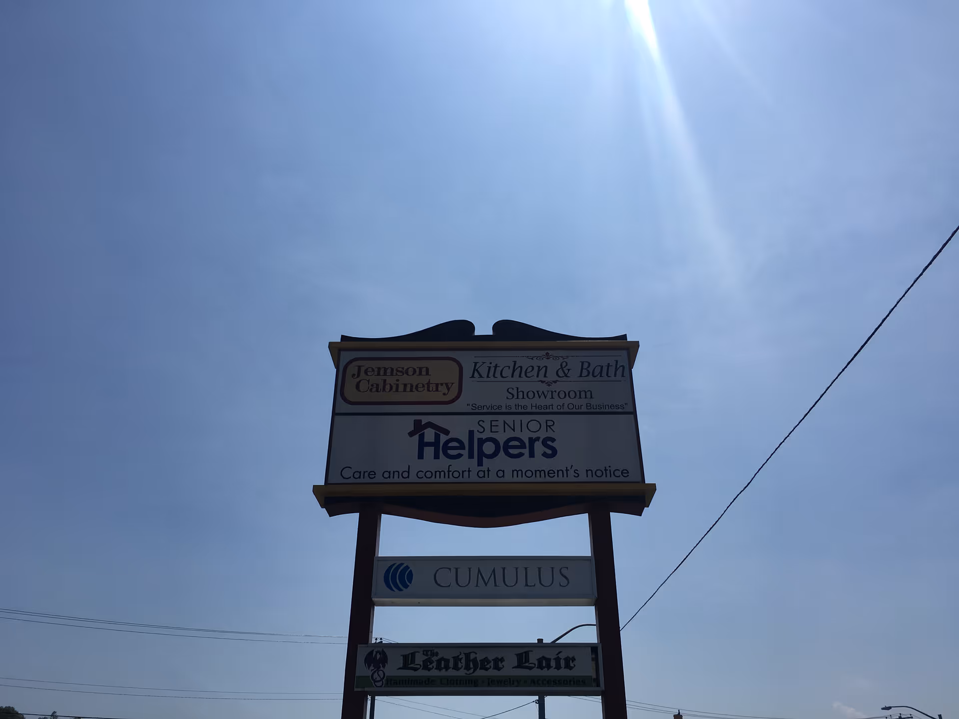 Tall outdoor signboard for Senior Helpers against a clear blue sky.