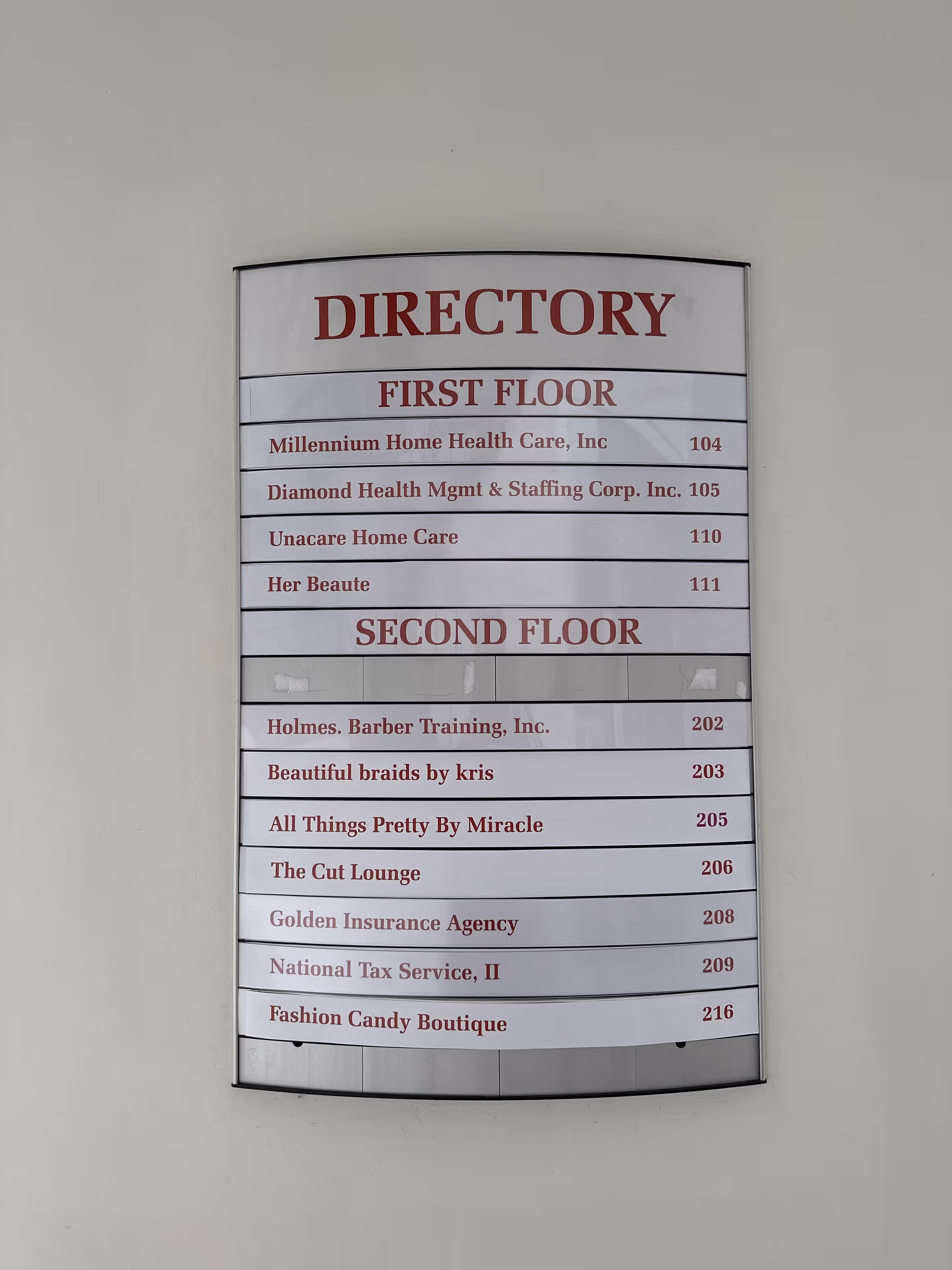 Directory sign listing tenants on first and second floors mounted on wall.