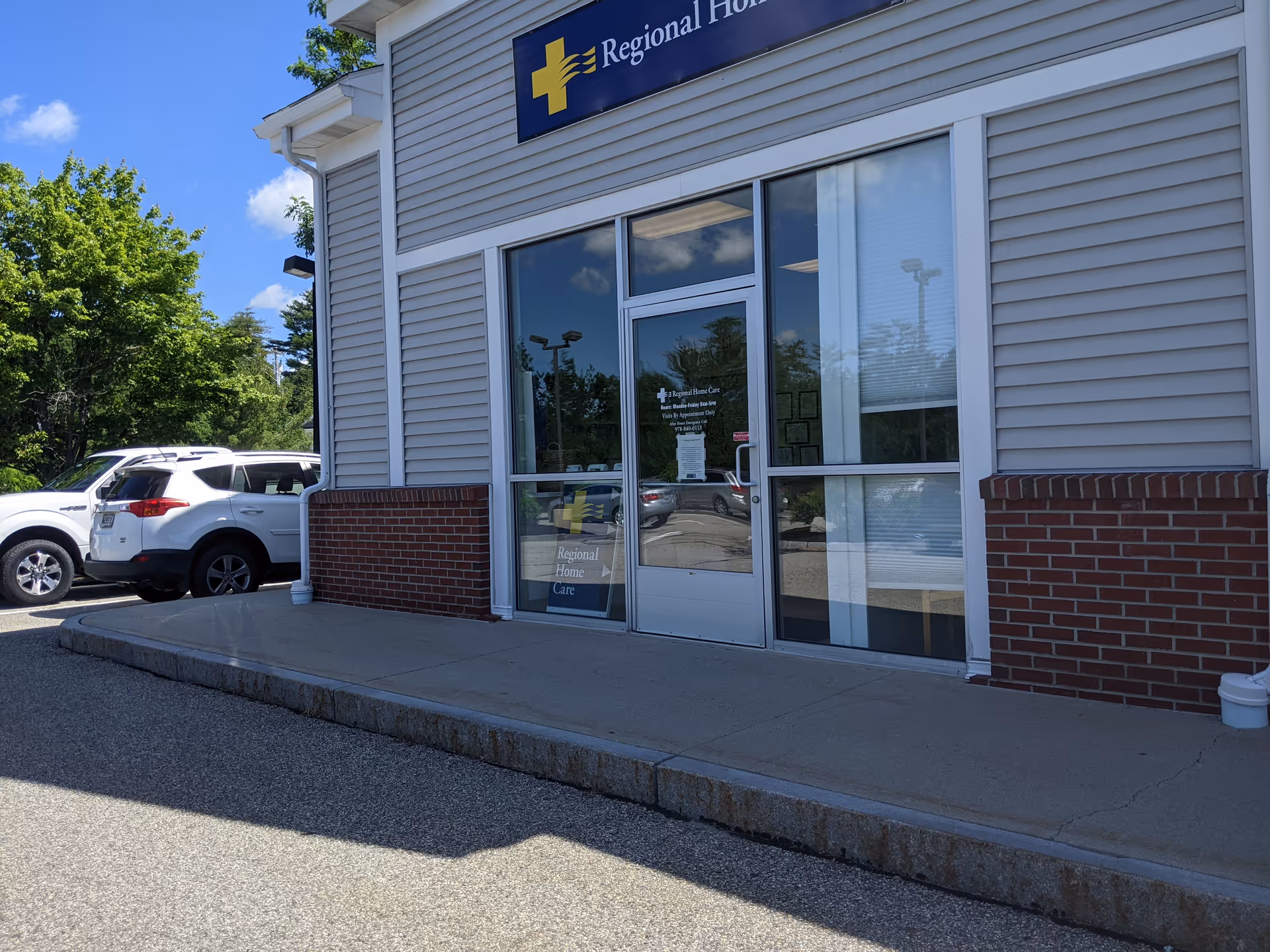 Front entrance of Regional Home Care facility with glass doors and parked cars nearby.