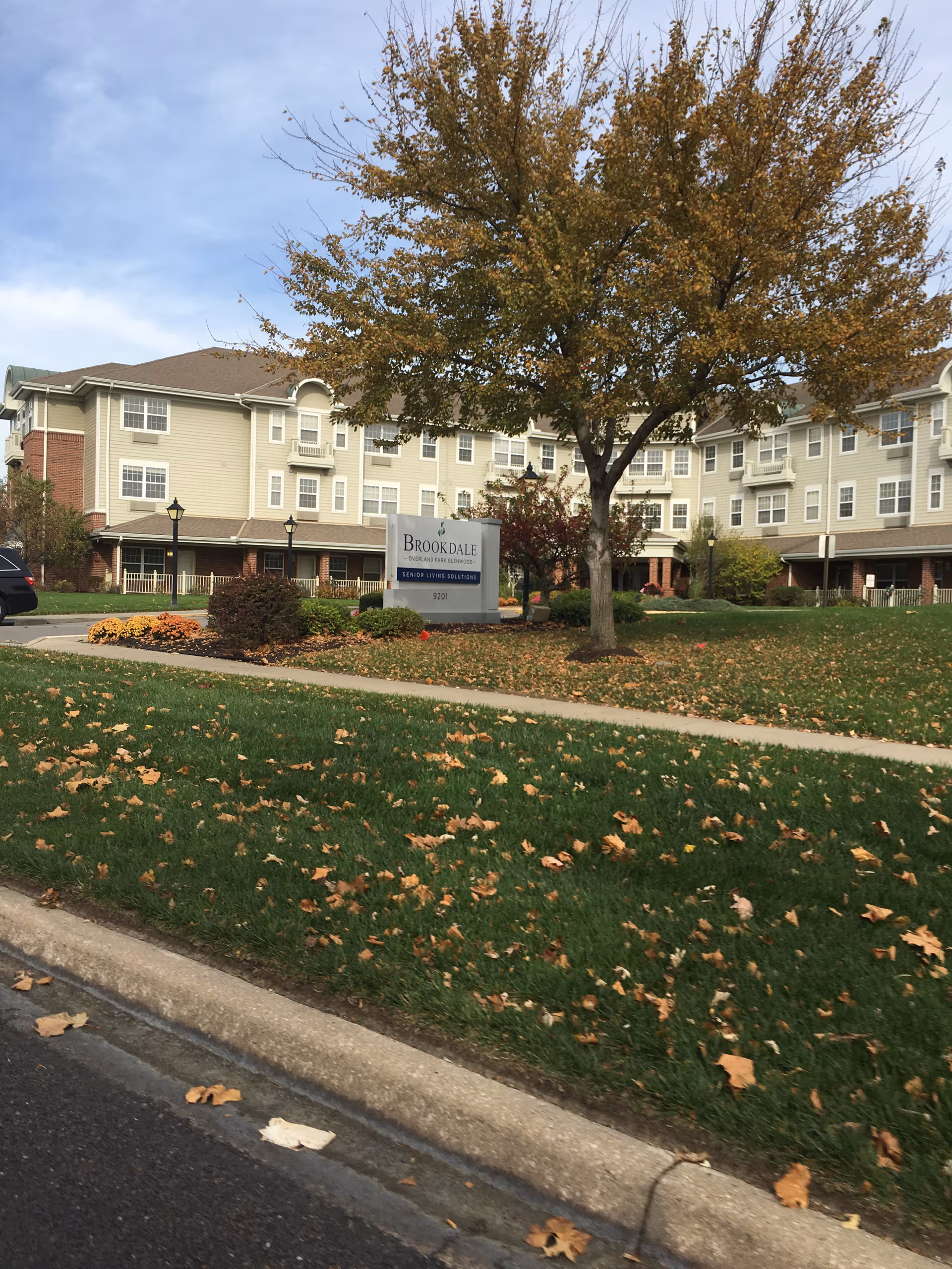 Exterior view of Pegasus Landing of Overland Park building with sign and autumn trees.