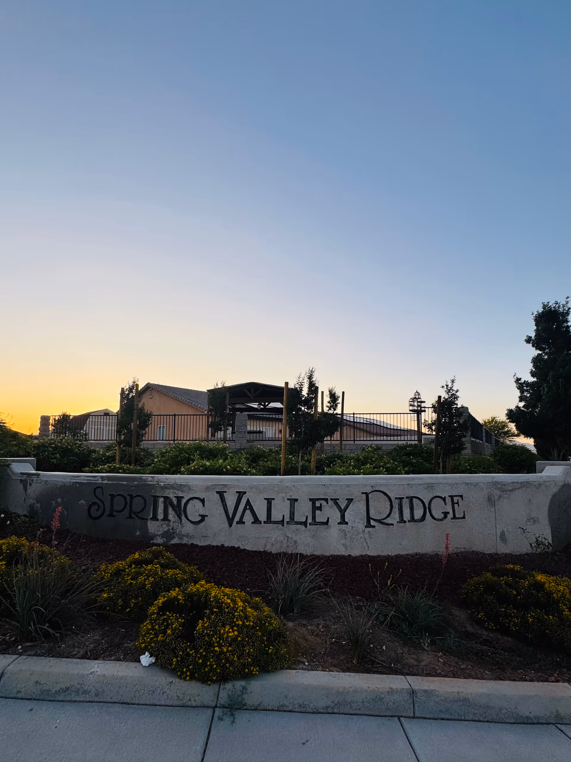 Front exterior of a senior living community with Spring Valley Ridge sign and landscaping.