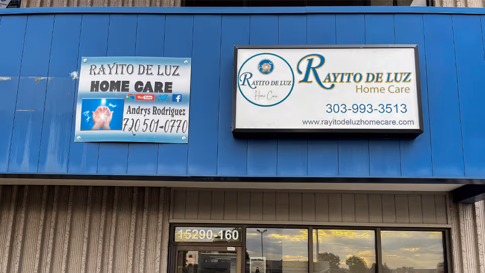 Blue storefront with Rayito de Luz Home Care signs and large glass windows.