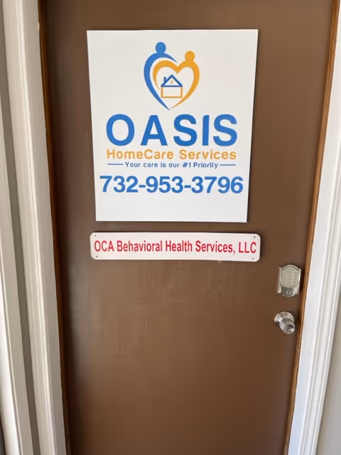 Brown interior door with Oasis HomeCare Services and OCA Behavioral Health Services signs.