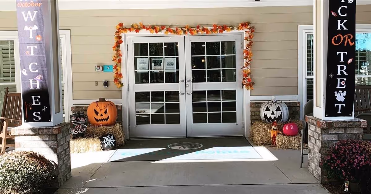Front entrance of Coastal Pointe Assisted Living with pumpkins and fall decorations.