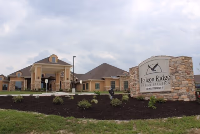 Exterior view of Falcon Ridge Rehabilitation with a stone sign and landscaped front