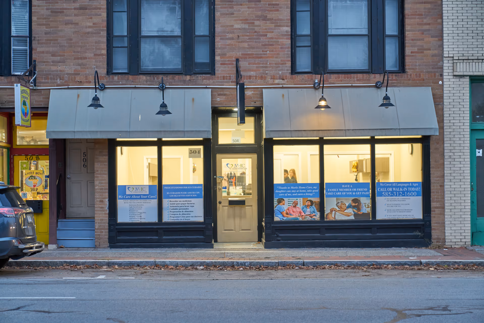Exterior storefront showing large windows, signage, and promotional posters for Marks Home Care Agency.